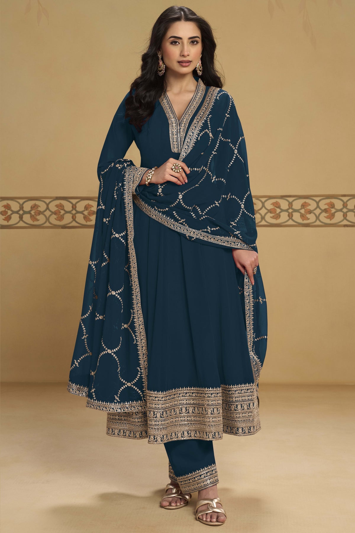 Close-up front view of a dark teal salwar suit in georgette with thread and sequin embroidered neckline and embroidered dupatta border.