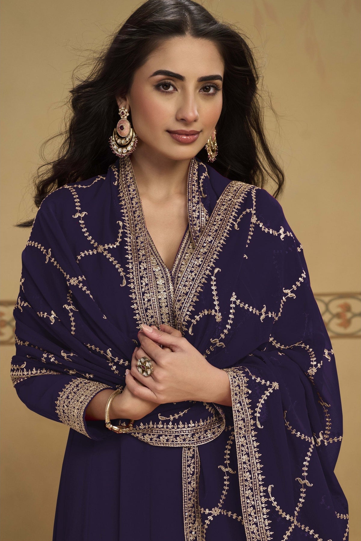 Close-up front view of a dark purple salwar kameez for wedding outfit in georgette with thread and sequin embroidered neckline.