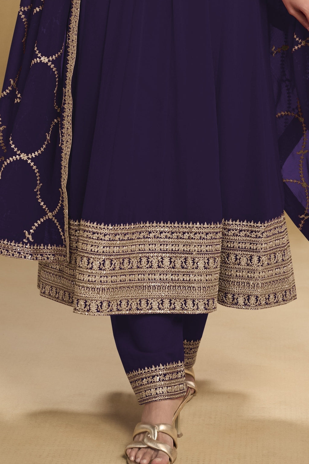 Waist-down detail view of a dark purple georgette salwar kameez with thread and sequin embroidery on the kurta hem and georgette pant.
