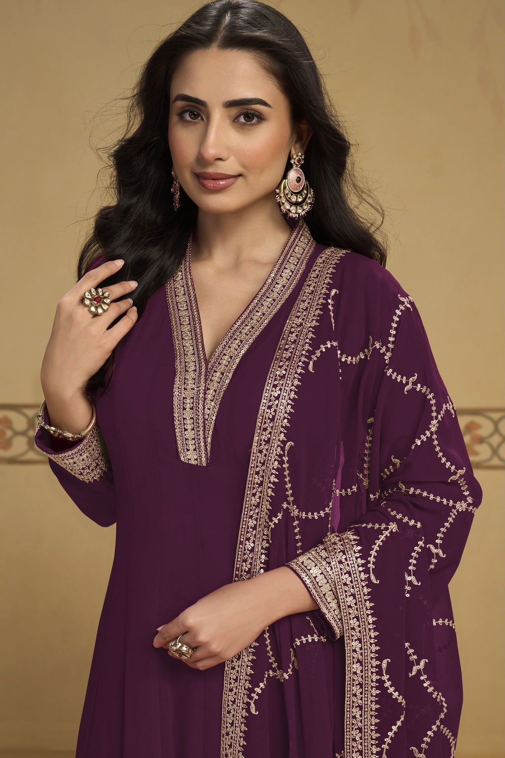 Woman wearing a plum indian kurta set in georgette with thread and sequin embroidery, georgette pant and dupatta, full-length front view.