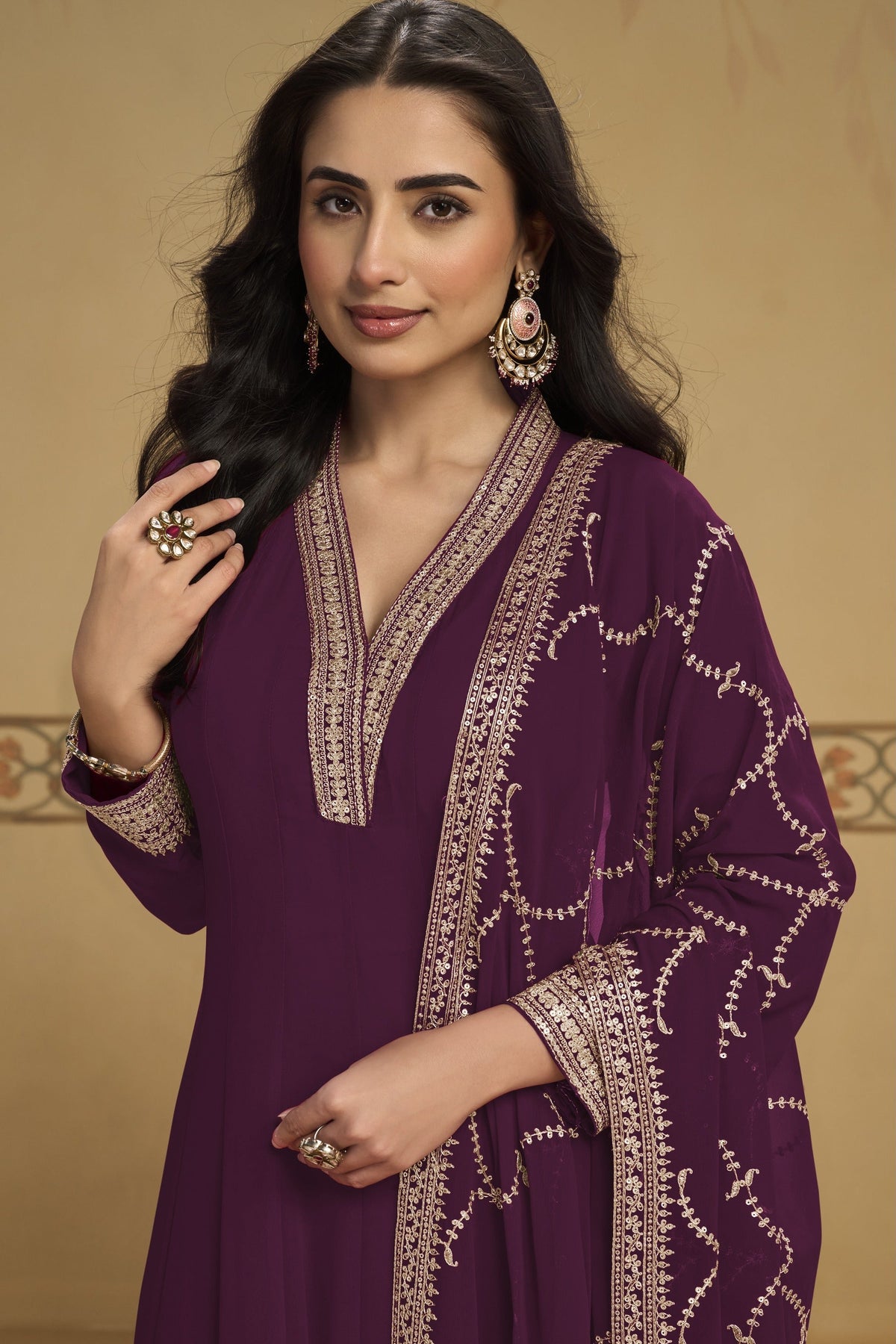 Woman wearing a plum indian kurta set in georgette with thread and sequin embroidery, georgette pant and dupatta, full-length front view.