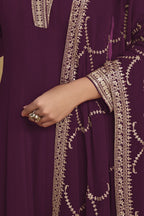 Waist-down detail view of a plum party wear salwar kameez in georgette with thread and sequin embroidery on kurta hem and pant.