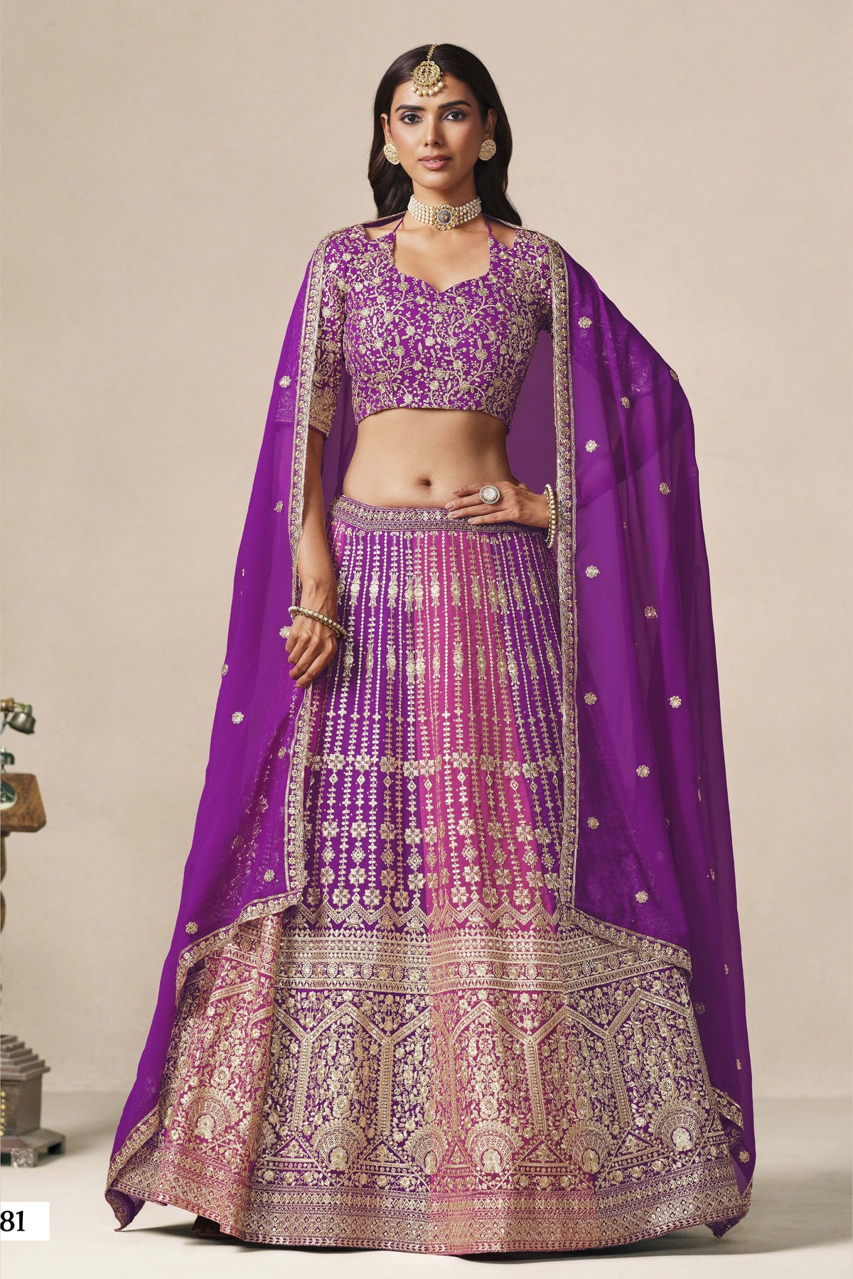 Woman wearing a purple lehenga for wedding in georgette with zari and sequin work, embroidered blouse and dupatta, full-length front view.