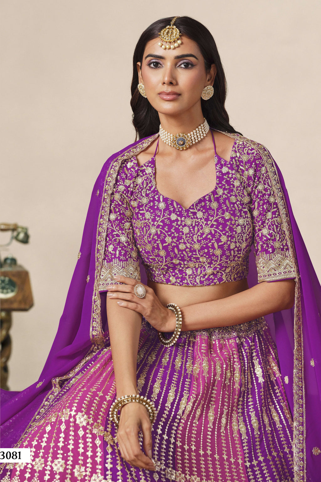 Close-up of a purple engagement lehenga blouse in georgette with zari and sequin work on the V neckline and elbow sleeves.
