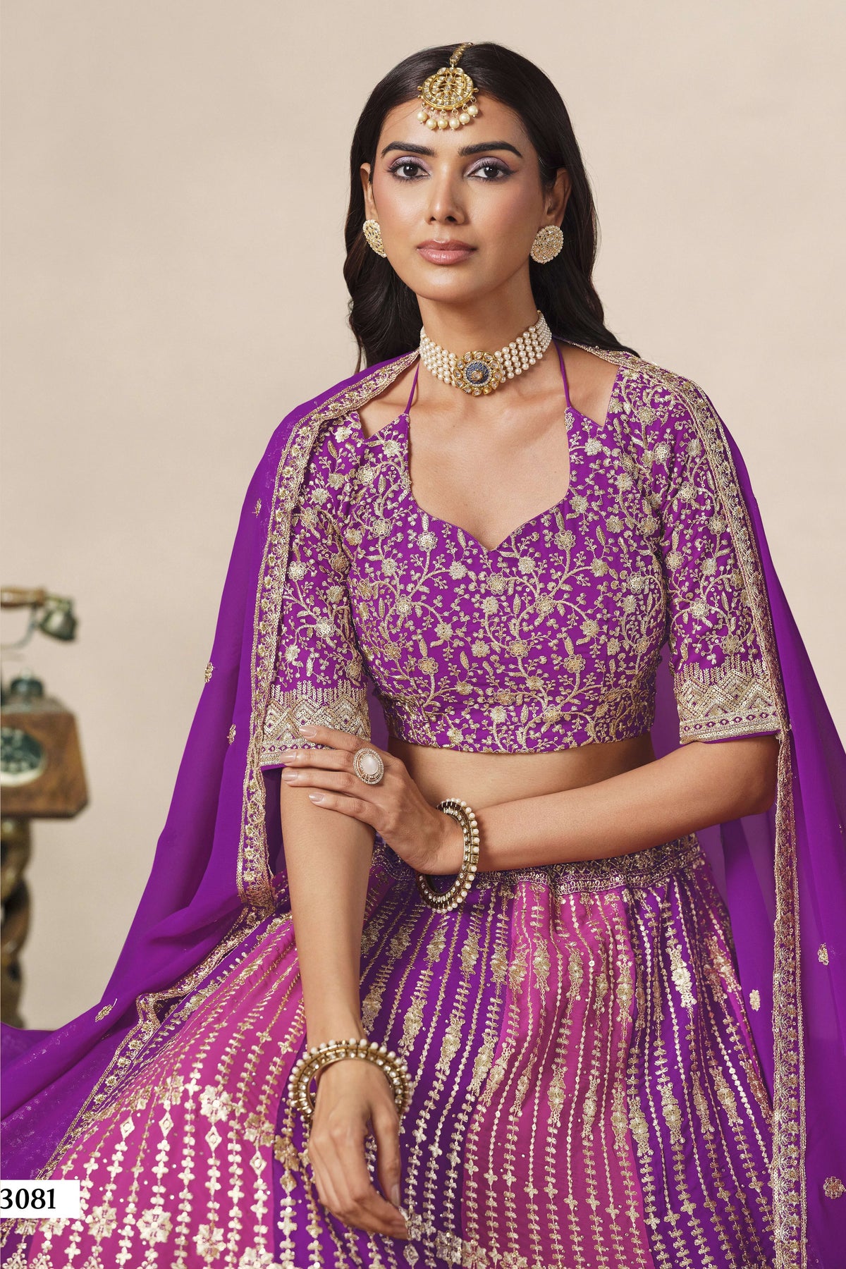 Close-up of a purple engagement lehenga blouse in georgette with zari and sequin work on the V neckline and elbow sleeves.
