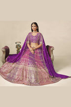 Full-length seated view of a purple indian wedding guest dresses style lehenga in georgette with zari and sequin work on the flared skirt.
