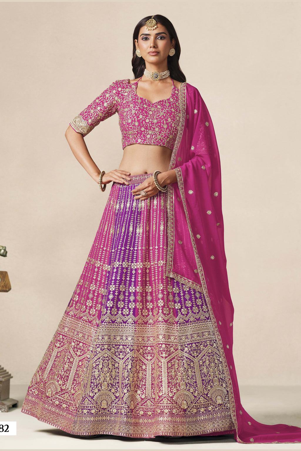 Full-length front view of a magenta lehenga for wedding in georgette with zari and sequin work and a flowing embroidered dupatta.