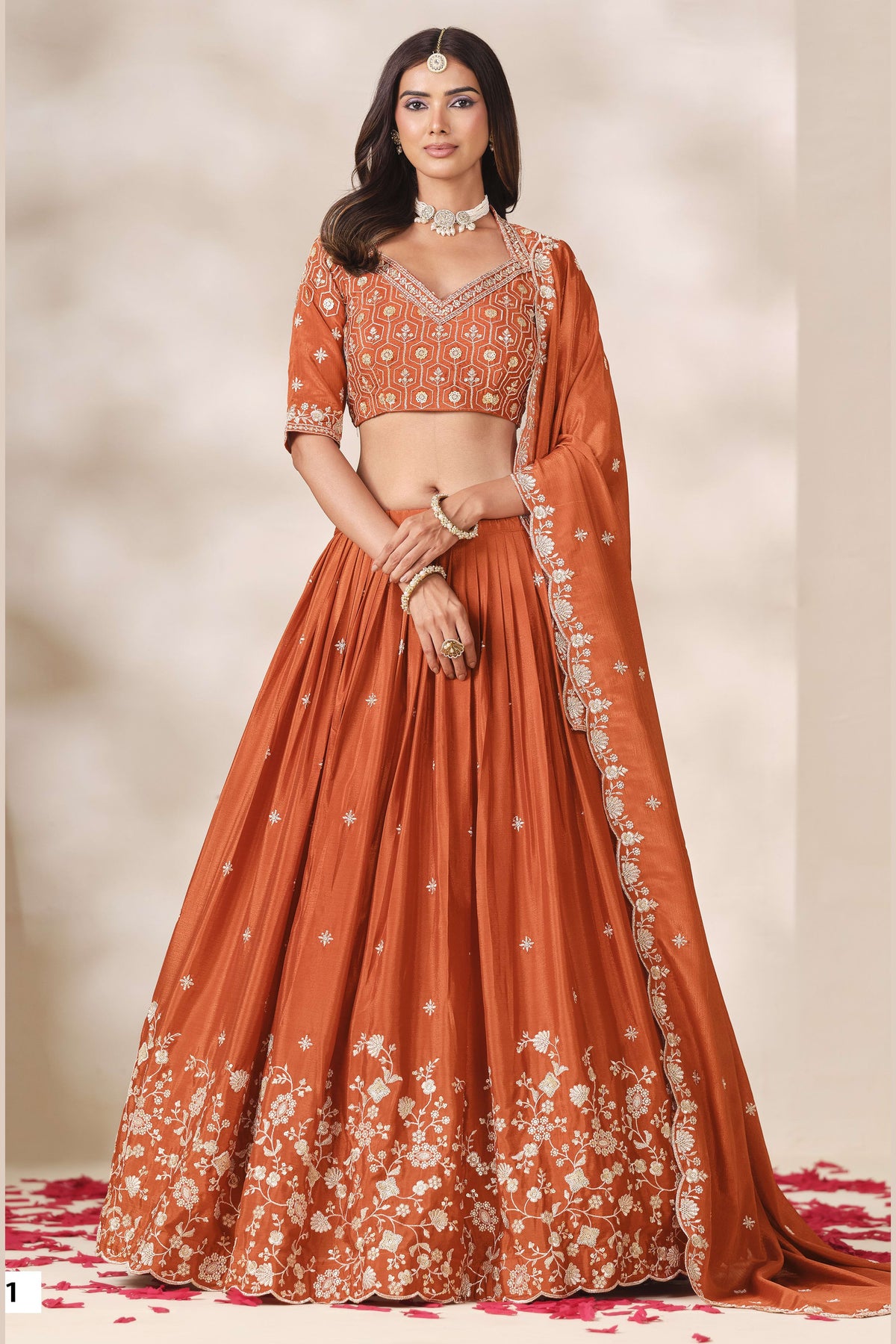 Another full-length front view of a rust orange festive wear for women lehenga in chinon silk with sequin and thread embroidery on the skirt hem.