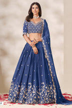 Woman wearing a dusty blue lehenga for sangeet in chinon silk with sequin and thread embroidery, embroidered blouse and dupatta, full-length front view.