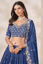 Close-up of a dusty blue engagement lehenga blouse in chinon silk with sequin and thread embroidery on the V neckline and elbow sleeves.