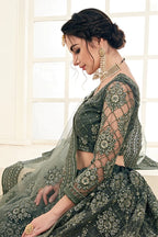 Woman wearing mahendi net lehenga choli with dupatta for Indian wedding