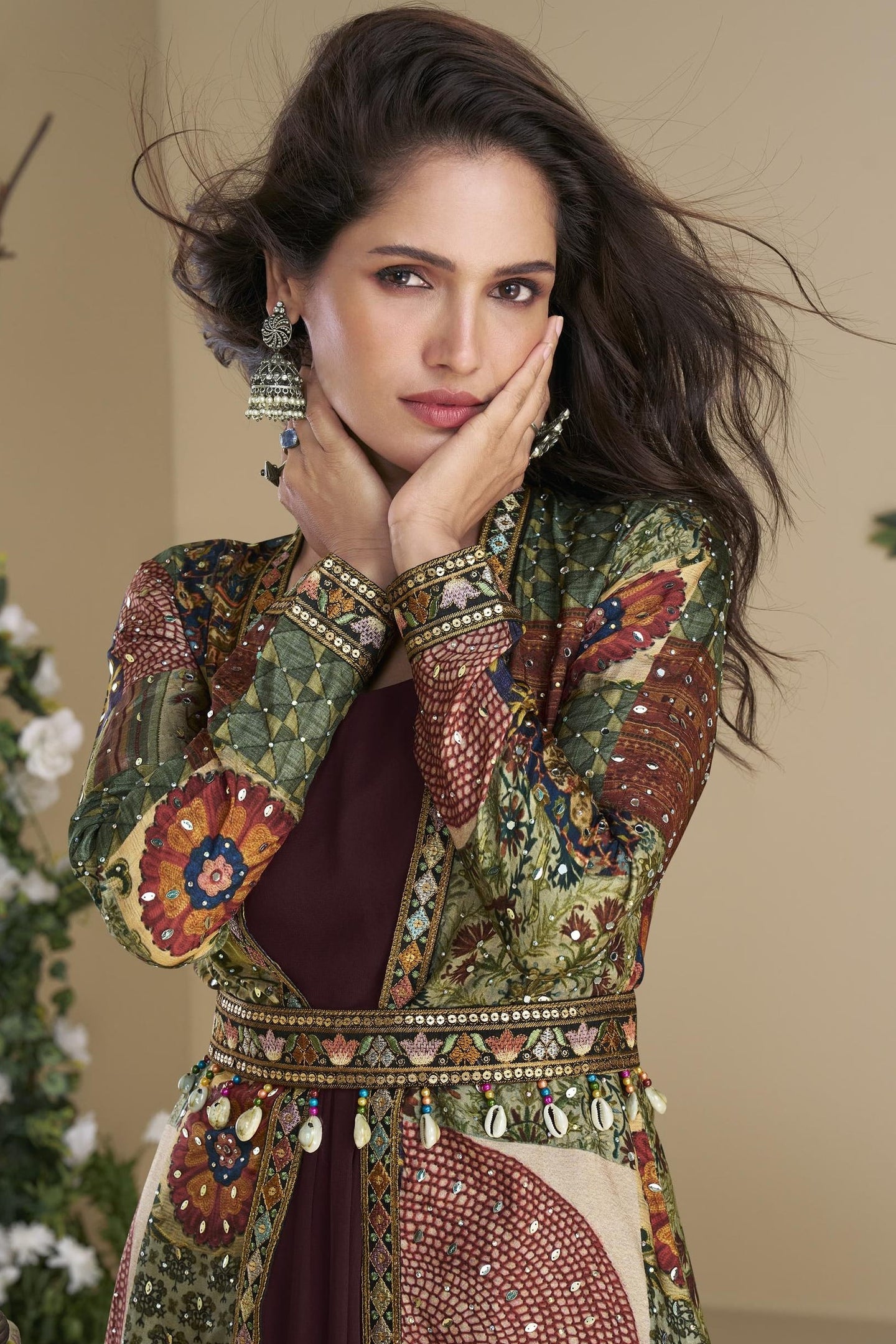 Woman wearing a traditional embroidered outfit with a neutral background