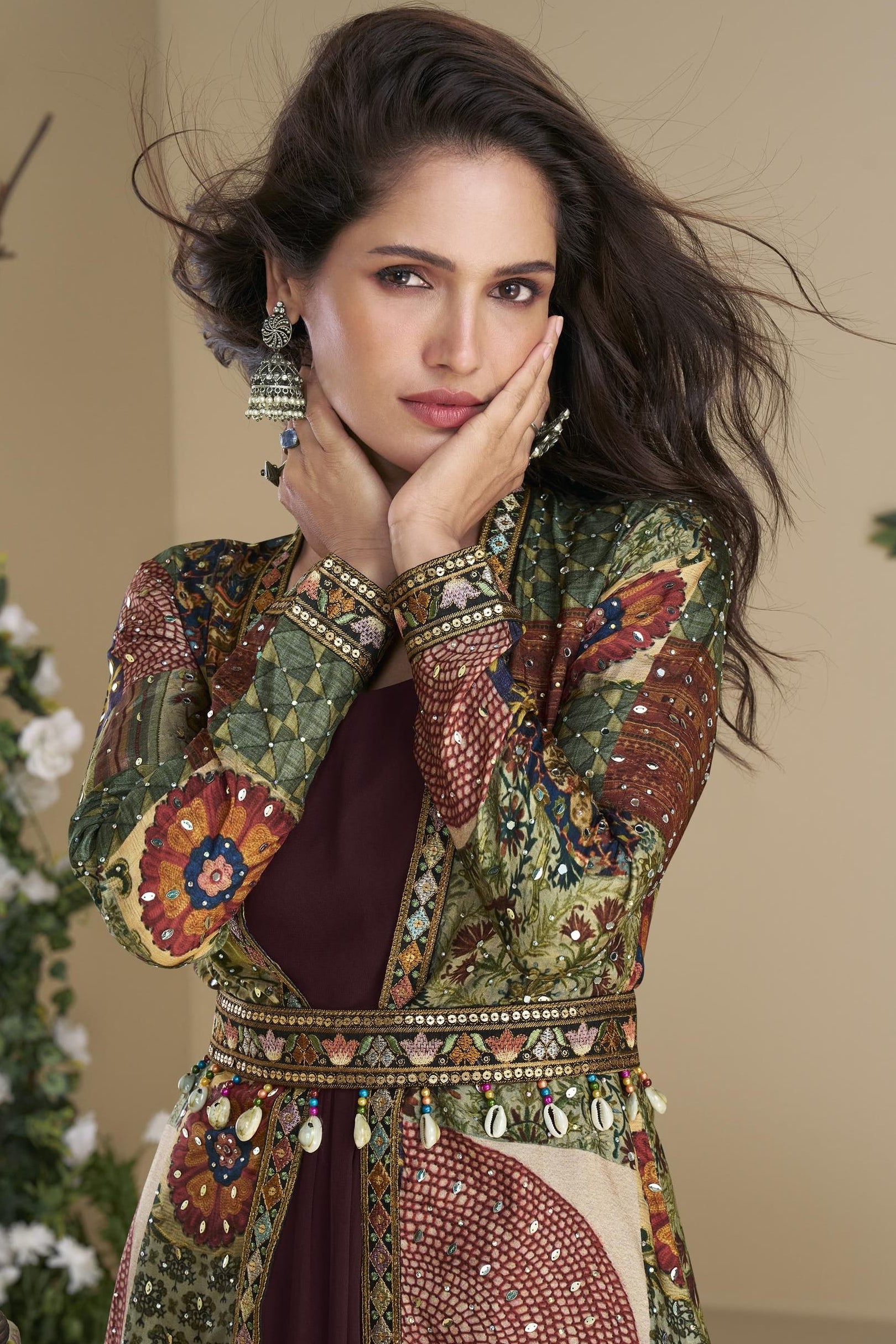 Woman wearing a traditional embroidered outfit with a neutral background