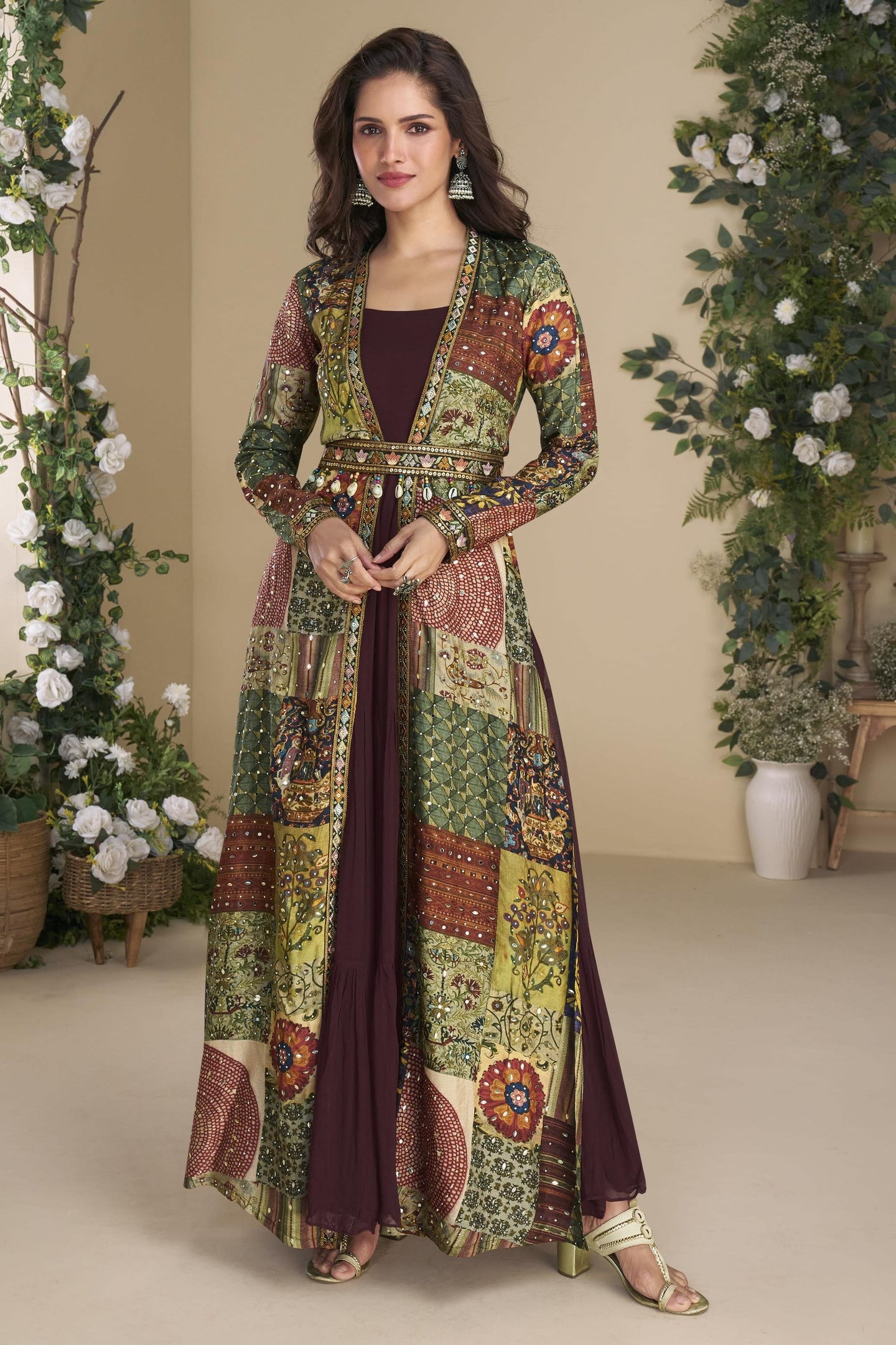 Woman wearing a long, patterned dress with floral designs in a decorated indoor setting.