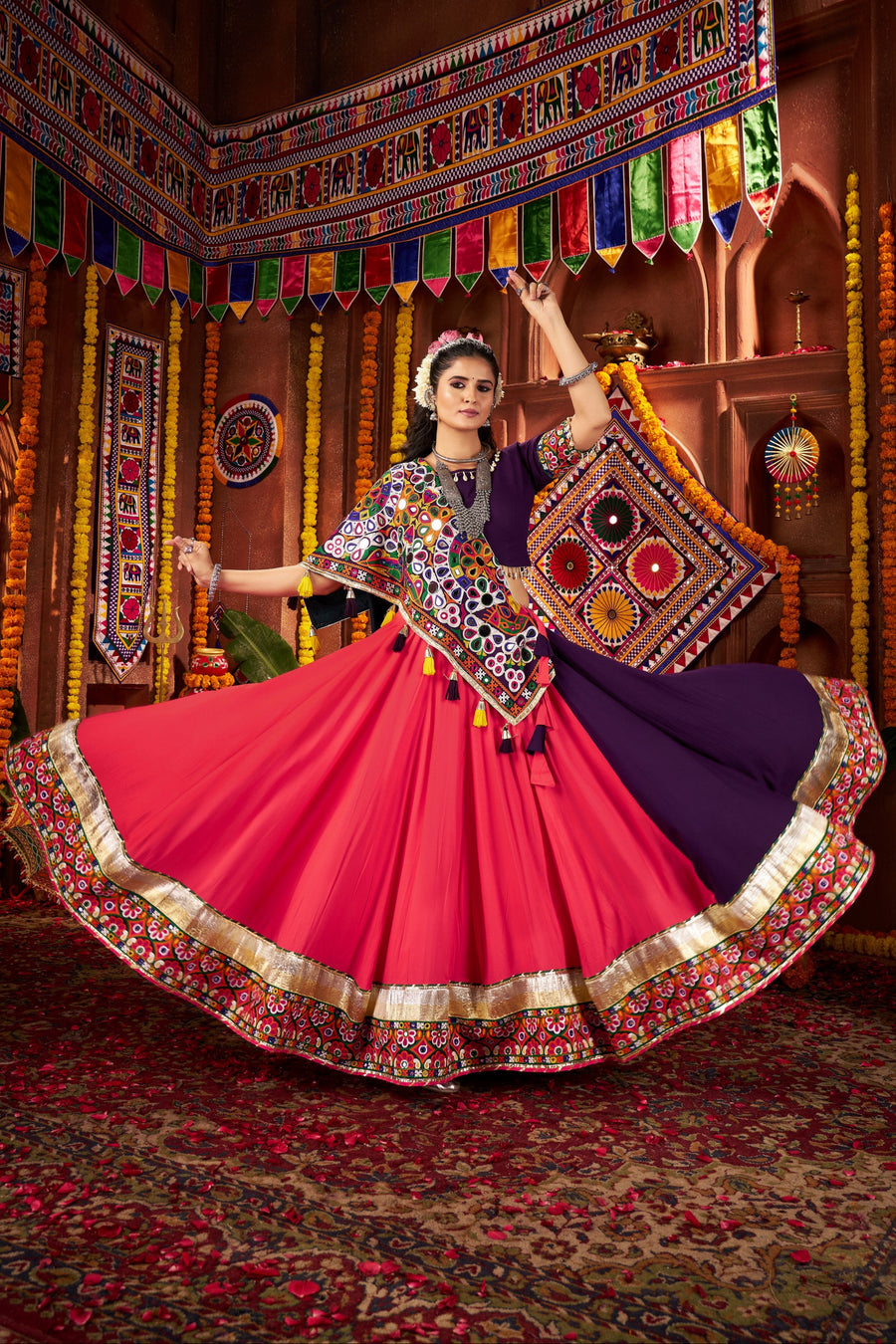 Woman in traditional Indian attire performing a dance in a decorated indoor setting