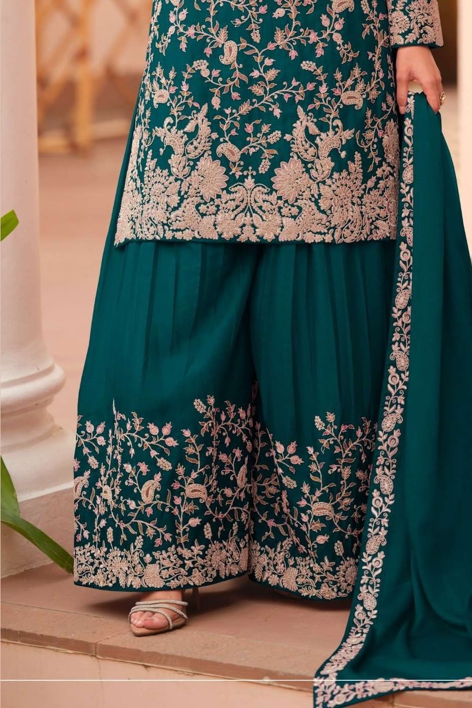 Waist-down detail view of a teal palazzo suit for women in chinon silk with thread embroidery work on the plazo hem and dupatta border.