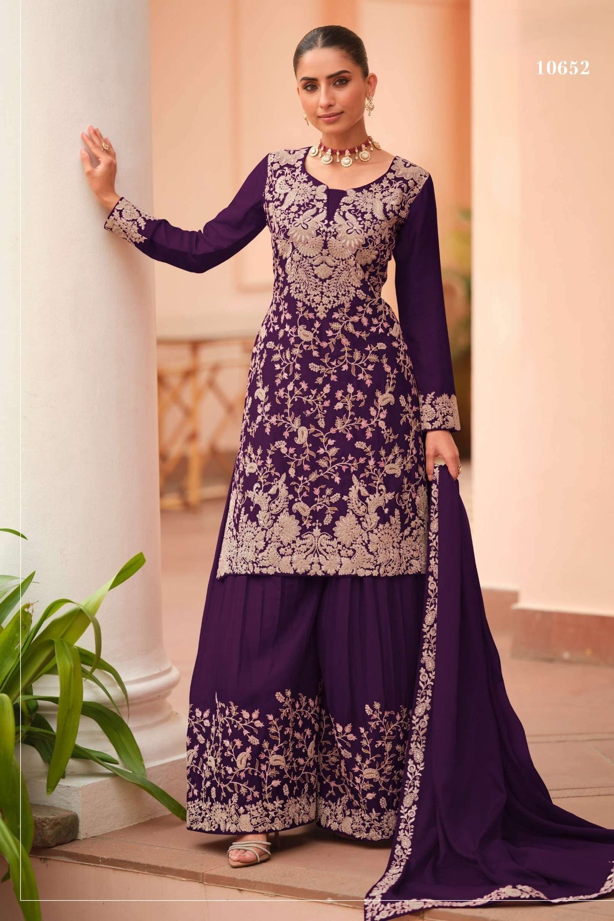 Woman wearing a dark purple palazzo suit for women in chinon silk with thread embroidery work, paired with an embroidered plazo and dupatta, full-length front view.