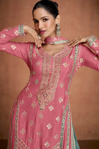 Woman wearing a pink and teal embroidered traditional outfit with 'Gulkapra' branding.