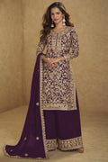 Woman wearing a traditional embroidered outfit with a purple dupatta against a beige background