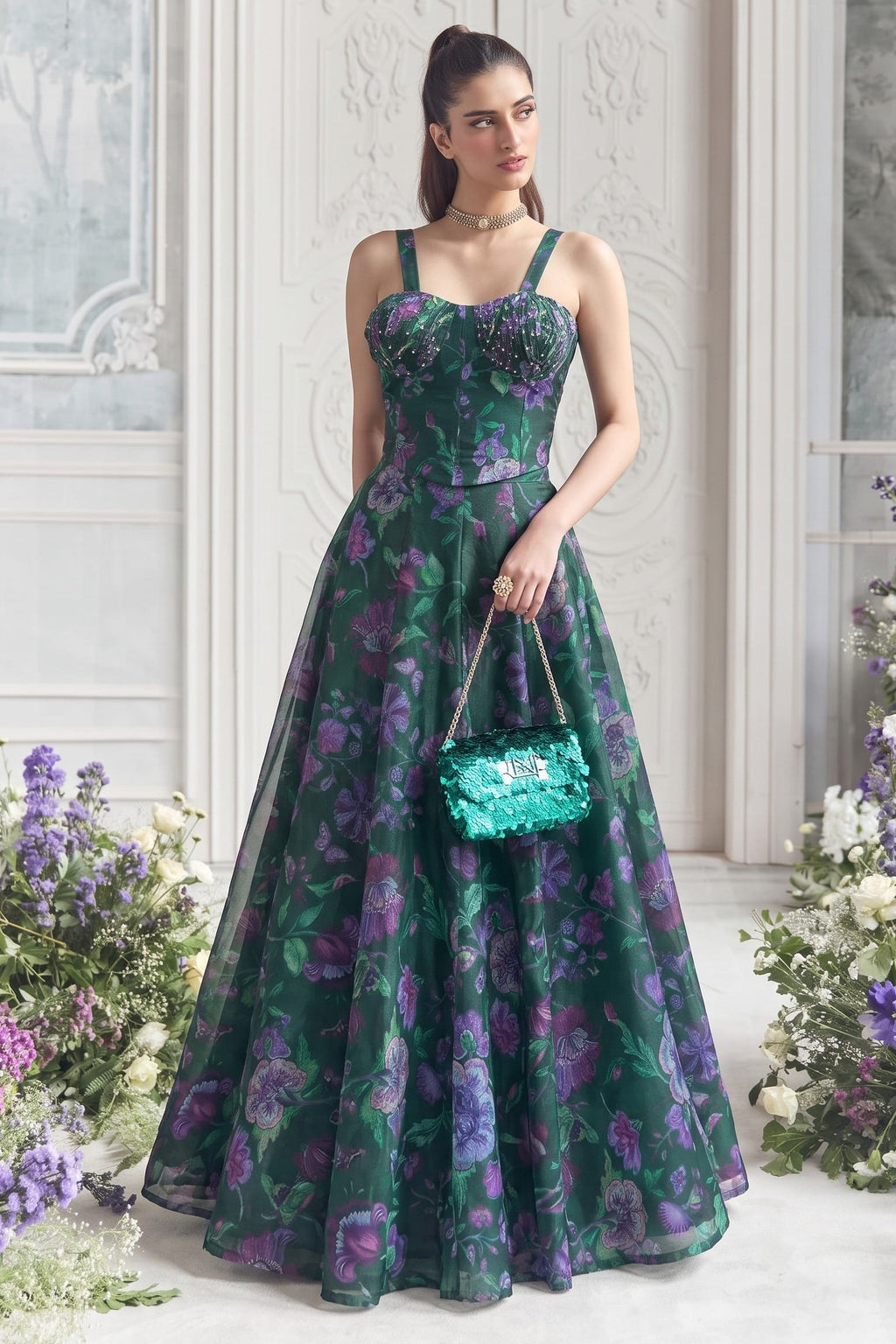 Bottle green party wear lehenga paired with a sequin clutch, styled for a wedding reception evening.
