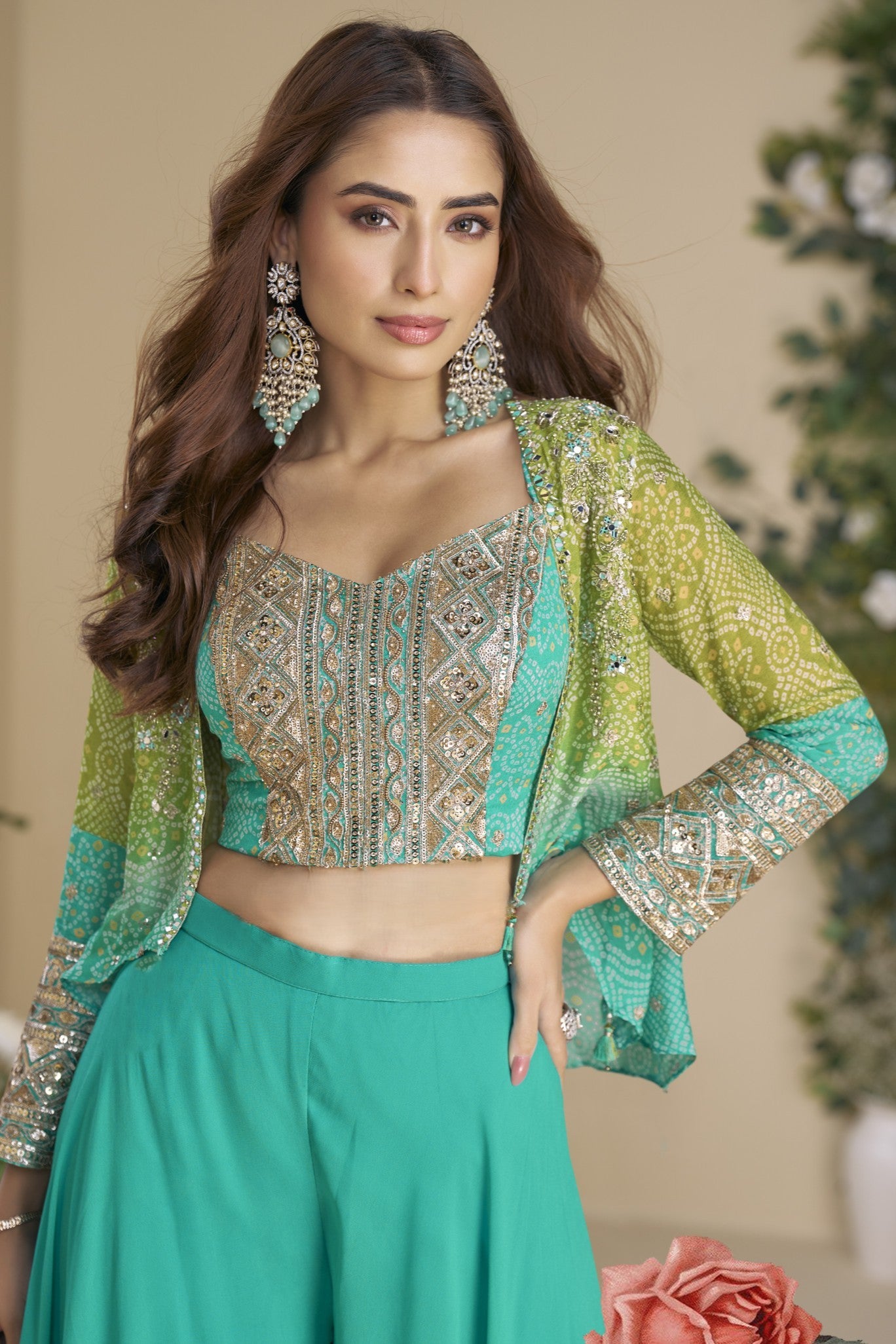 Woman wearing a teal and silver traditional outfit with floral background