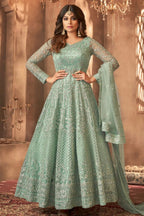 A woman poses in a full-length portrait wearing an embroidered light green anarkali suit with a matching dupatta, an elegant choice among mehndi outfits for guests.