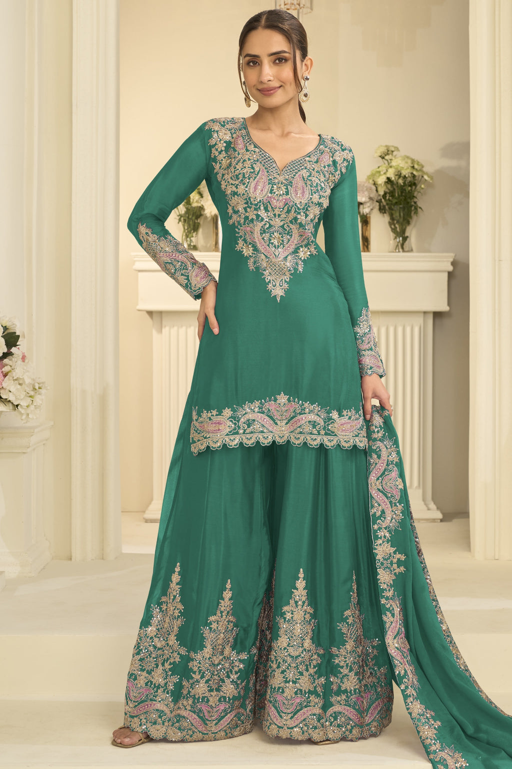 Woman wearing a teal palazzo suit in chinon silk with thread and sequin embroidery, embroidered plazo and dupatta, full-length front view.