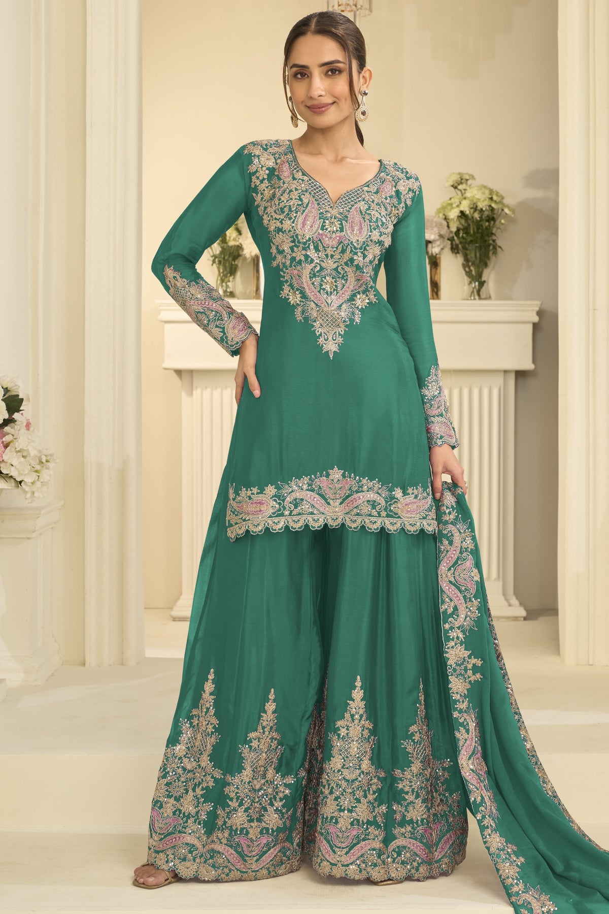 Woman wearing a teal palazzo suit in chinon silk with thread and sequin embroidery, embroidered plazo and dupatta, full-length front view.