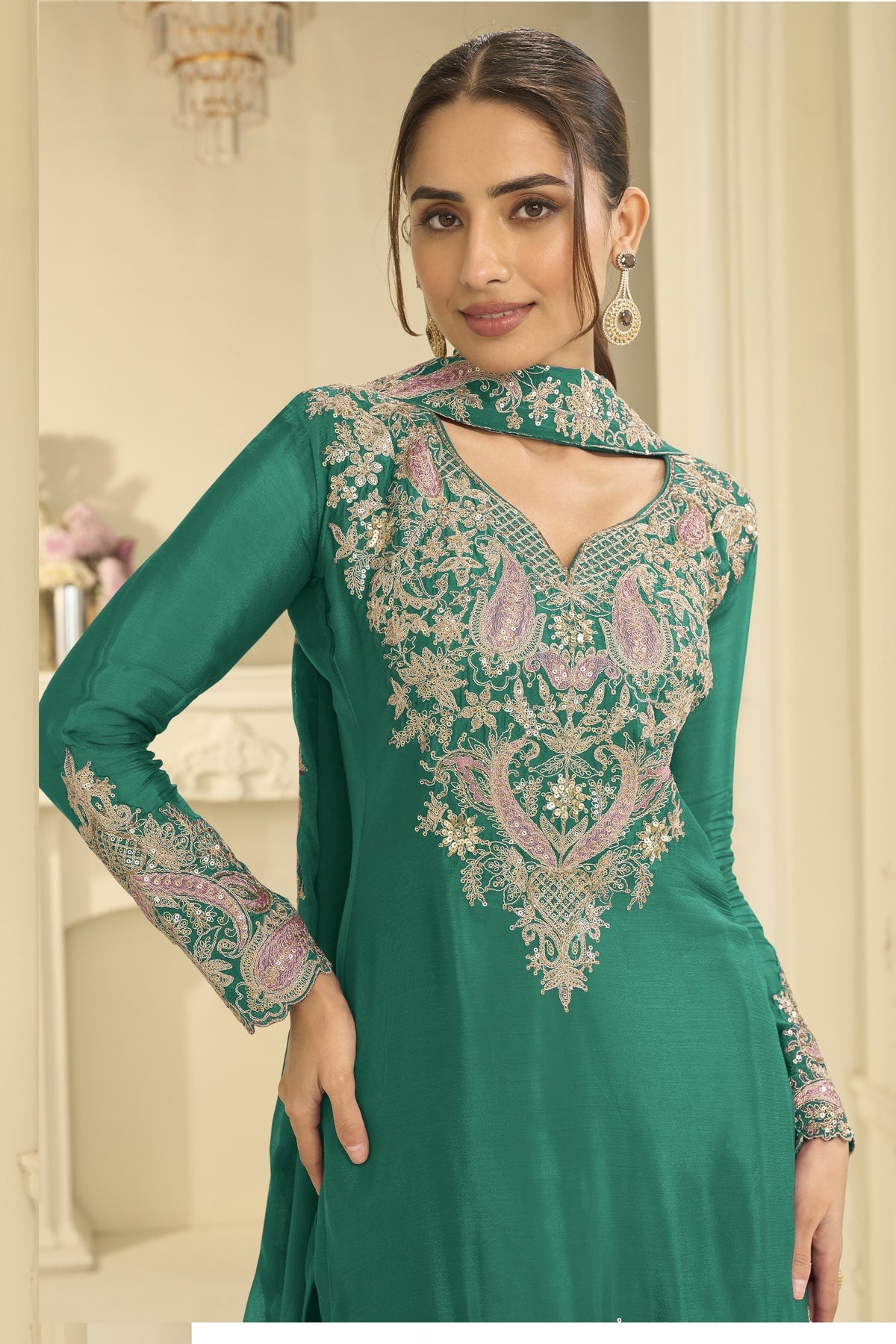 Close-up of a teal festive wear for women plazo suit bodice in chinon silk with thread and sequin embroidery on the neckline and sleeves.