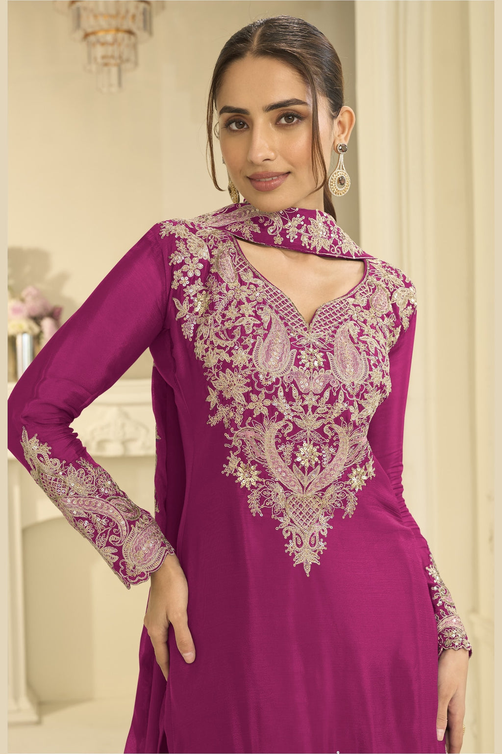 Close-up of a magenta palazzo suit bodice in chinon silk with delicate thread and sequin embroidery on the neckline and sleeves.