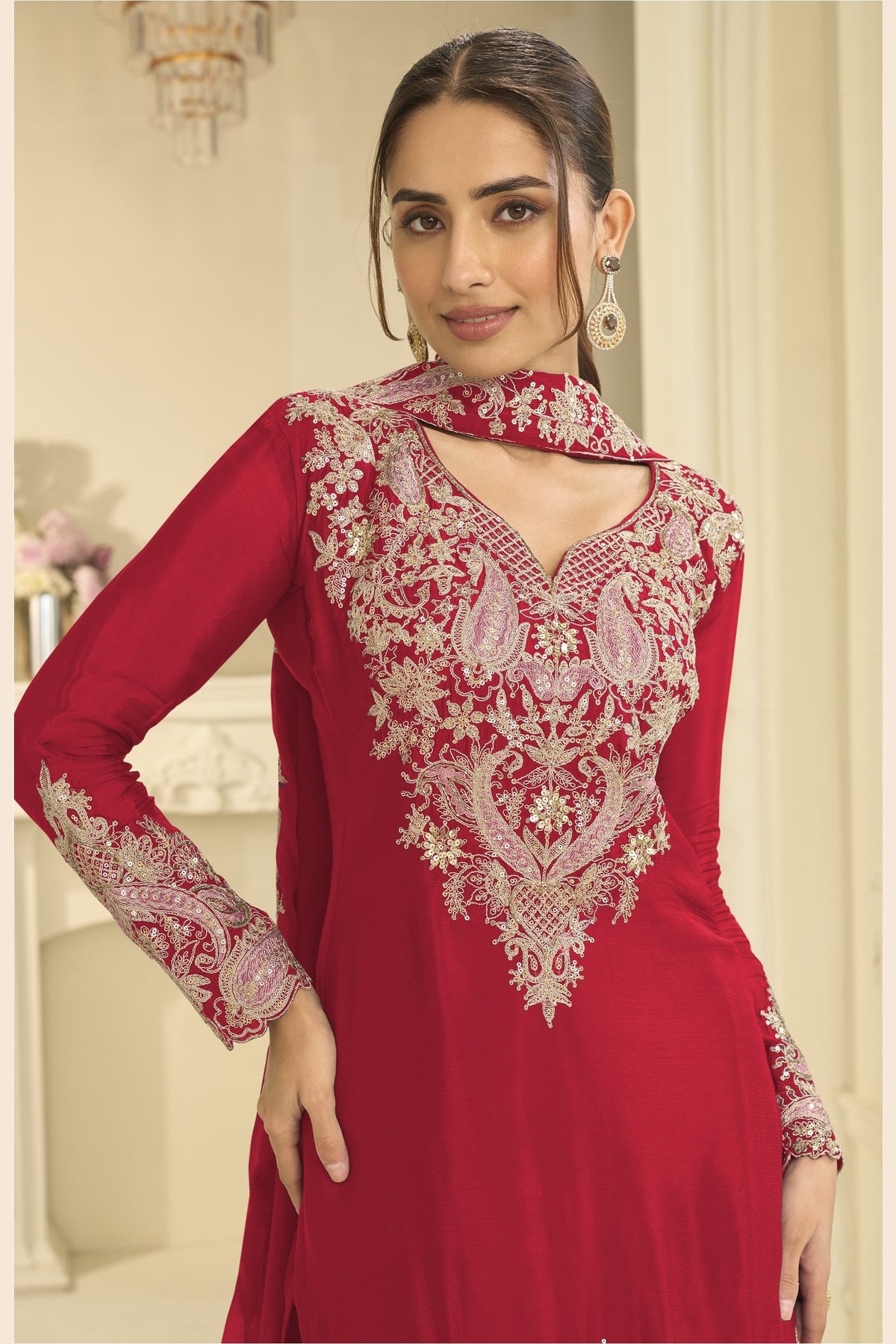 Close-up of a red palazzo dress bodice in chinon silk with delicate thread and sequin embroidery on the neckline and sleeves.