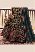Lower view of a dark green ladies party wear lehenga with an embroidered net lehenga skirt and matching net dupatta drape.