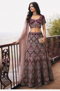 Woman wearing a maroon punjabi lehenga for wedding with embroidery work, short sleeve round neck net choli, full-length front view.