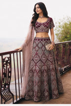 Woman wearing a maroon punjabi lehenga for wedding with embroidery work, short sleeve round neck net choli, full-length front view.