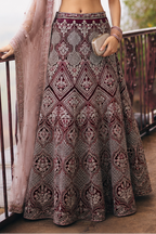 Lower view of a maroon wedding reception lehenga with embroidered net lehenga skirt and matching dupatta drape. All-over embroidery.