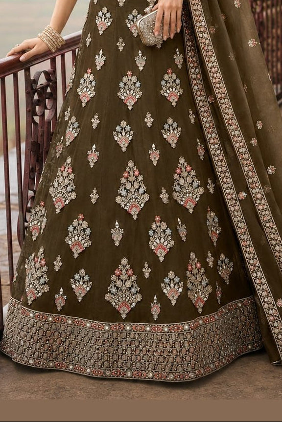 Lower view of a brown georgette lehenga for women with embroidered net lehenga skirt and matching dupatta drape. All-over embroidery.