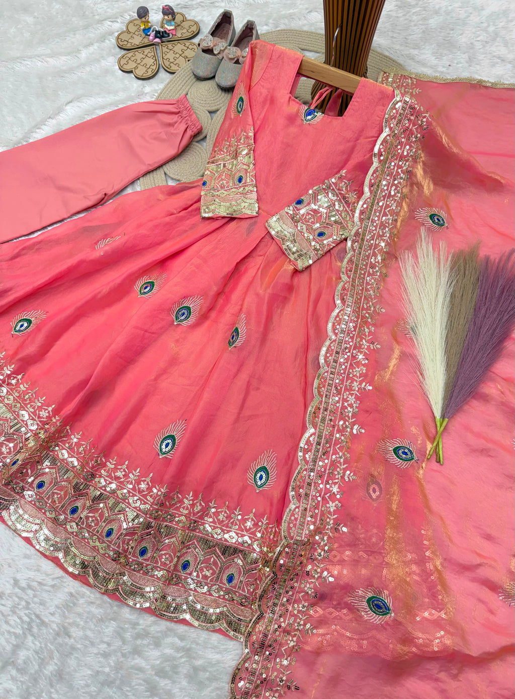 Coral pink childrens indian outfits girls anarkali set flat lay with cotton pant and embroidered fendy silk dupatta.