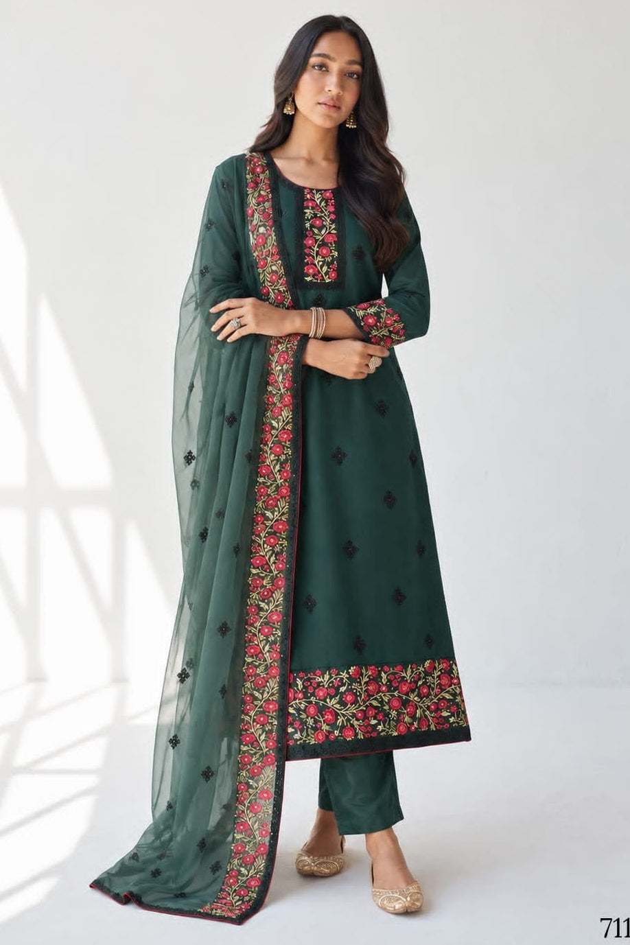 
Front view of a dark green pakistani suits style kameez with all-over thread and sequin embroidery, straight pant and sheer net dupatta on one shoulder.