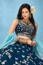 Half view of a navy blue lehenga choli for wedding guest, showing the sleeveless sweetheart blouse and the worked rangoli silk dupatta.