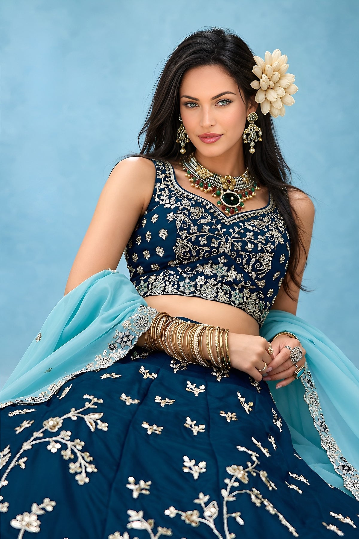 Half view of a navy blue lehenga choli for wedding guest, showing the sleeveless sweetheart blouse and the worked rangoli silk dupatta.