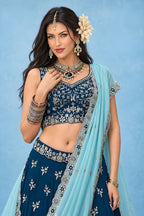 Half front view of a navy blue lehengas for wedding guest outfit, highlighting the sweetheart neckline and the detailed work on the blouse.