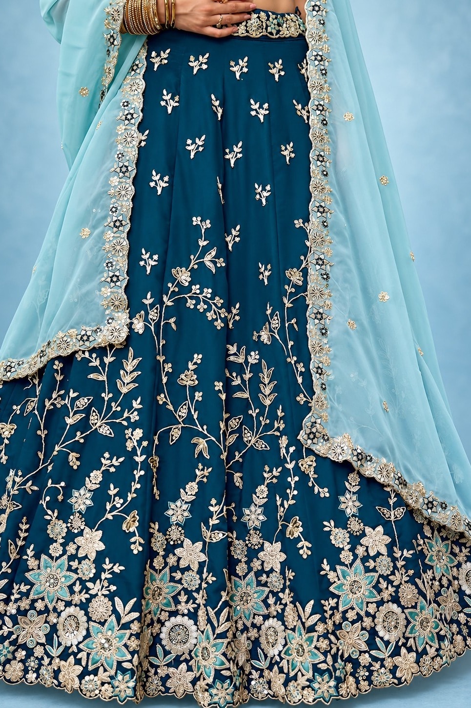 Waist-down closeup of a navy blue lehenga choli for wedding guest, showing the flared rangoli silk skirt and its zari, sequin and thread detailing.