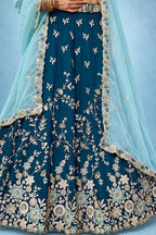 Waist-down closeup of a navy blue lehenga choli for wedding guest, showing the flared rangoli silk skirt and its zari, sequin and thread detailing.