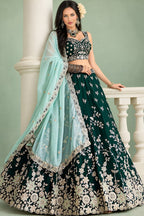 A dark green lehenga mehendi with a sleeveless sweetheart blouse, flared rangoli silk skirt and mint dupatta, shown in a full front view by a pillar.