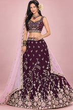 A maroon lehenga for reception with a sleeveless sweetheart blouse, flared rangoli silk skirt and light pink dupatta, shown in a full front view.