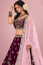 Half front view of a maroon lehenga for marriage reception, highlighting the sleeveless sweetheart blouse and the worked dupatta.