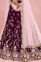 Waist-down closeup of a maroon lehenga for marriage reception, showing the flared rangoli silk skirt and its detailed work.