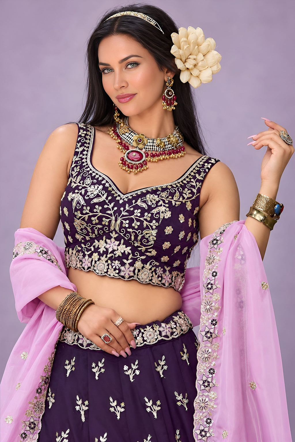 Half front view of a dark purple lehenga sangeet outfit, highlighting the sweetheart neckline blouse and the worked lavender dupatta.