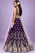 Back view of dark purple sangeet lehengas showing the deep back neckline and the work carried on the back of the blouse and skirt.