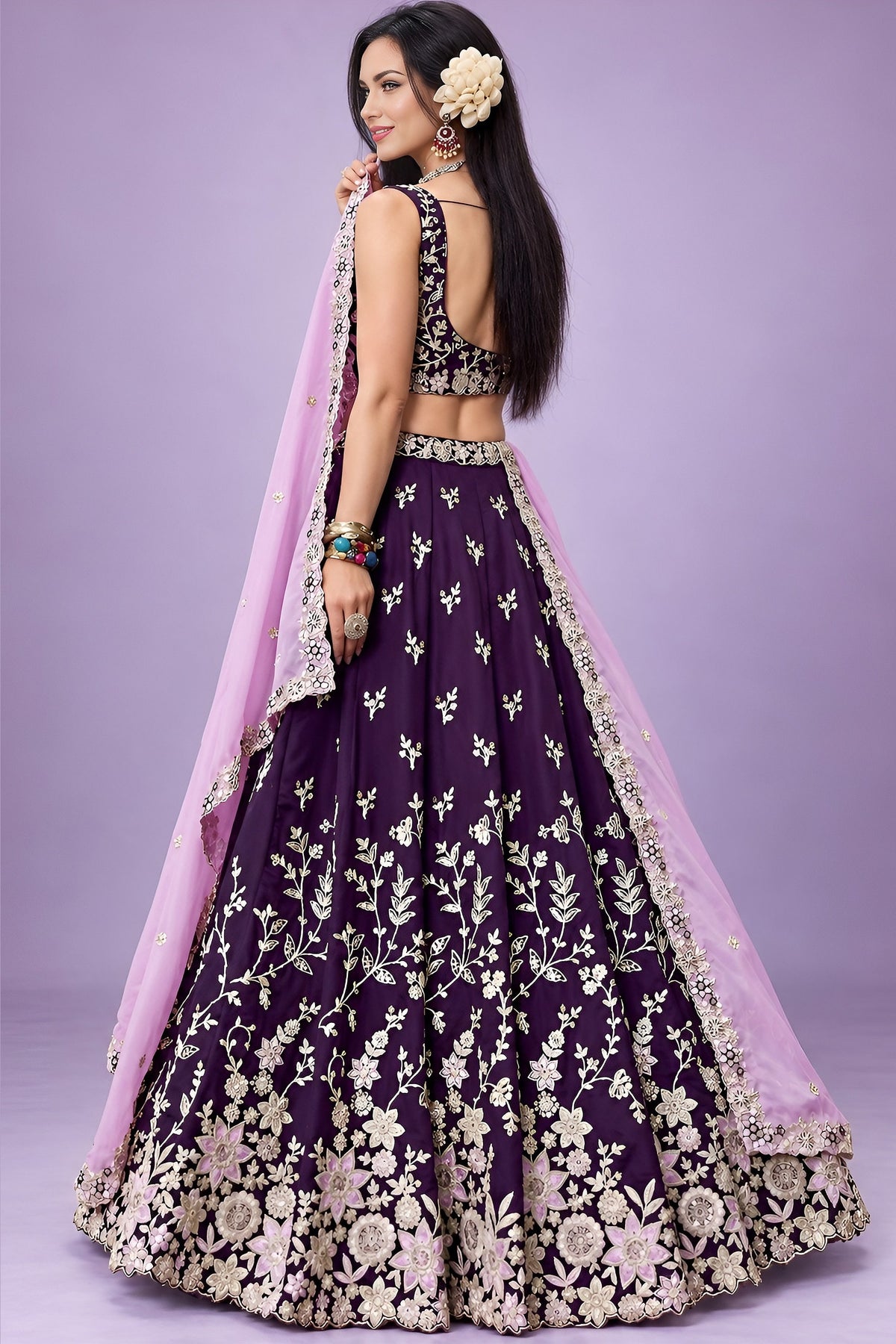 Back view of dark purple sangeet lehengas showing the deep back neckline and the work carried on the back of the blouse and skirt.